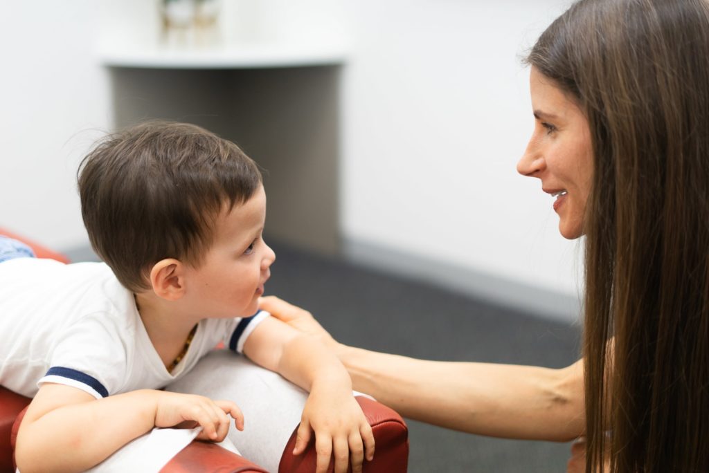 Chiropractor looking into young boys eyes.